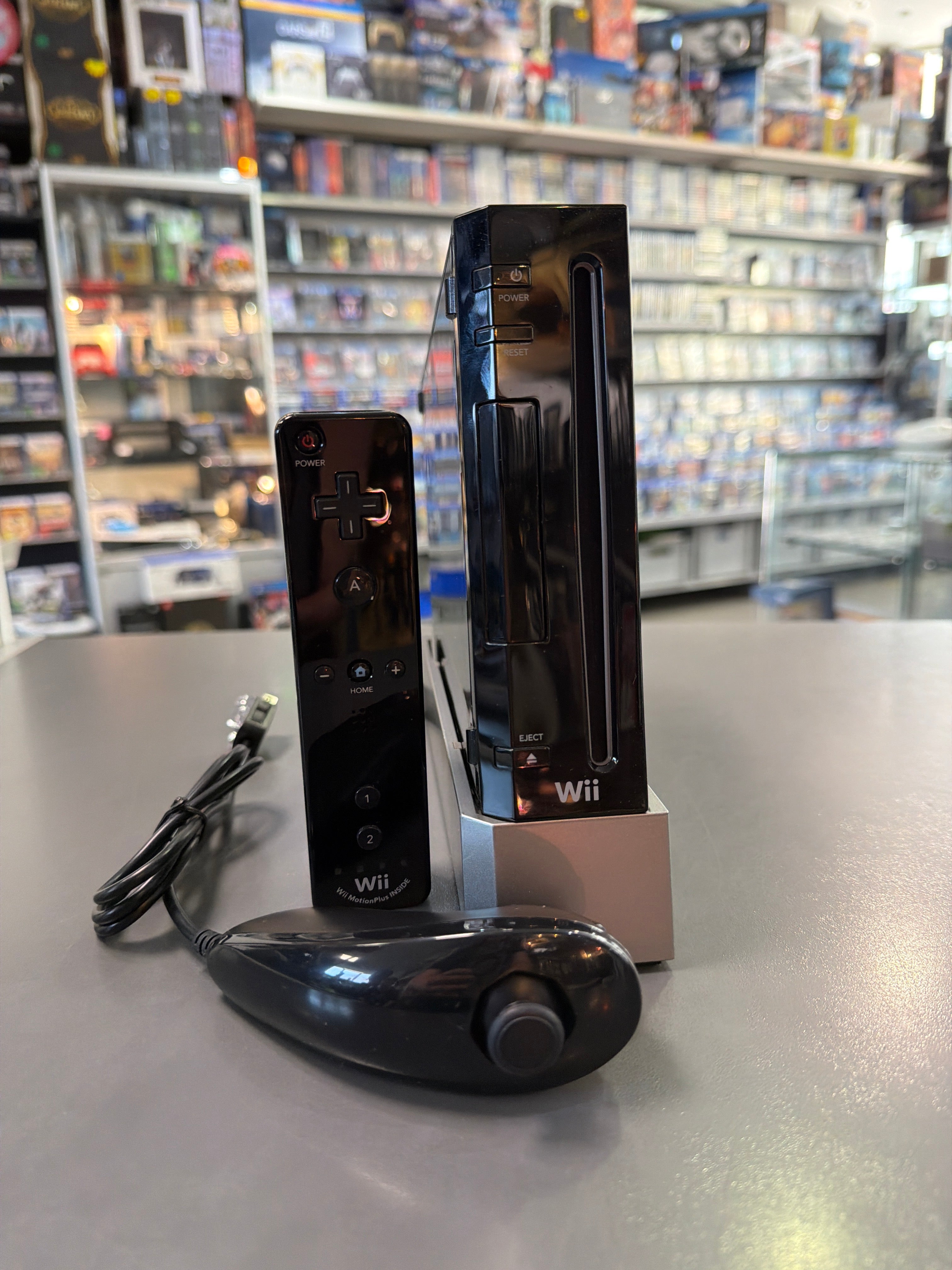 Schwarze Nintendo Wii Konsole mit Controller, Sensorleiste, Netzteil und Anschlusskabeln, gebraucht mit altersbedingten Gebrauchsspuren, GameCube-kompatibel und voll funktionsfähig