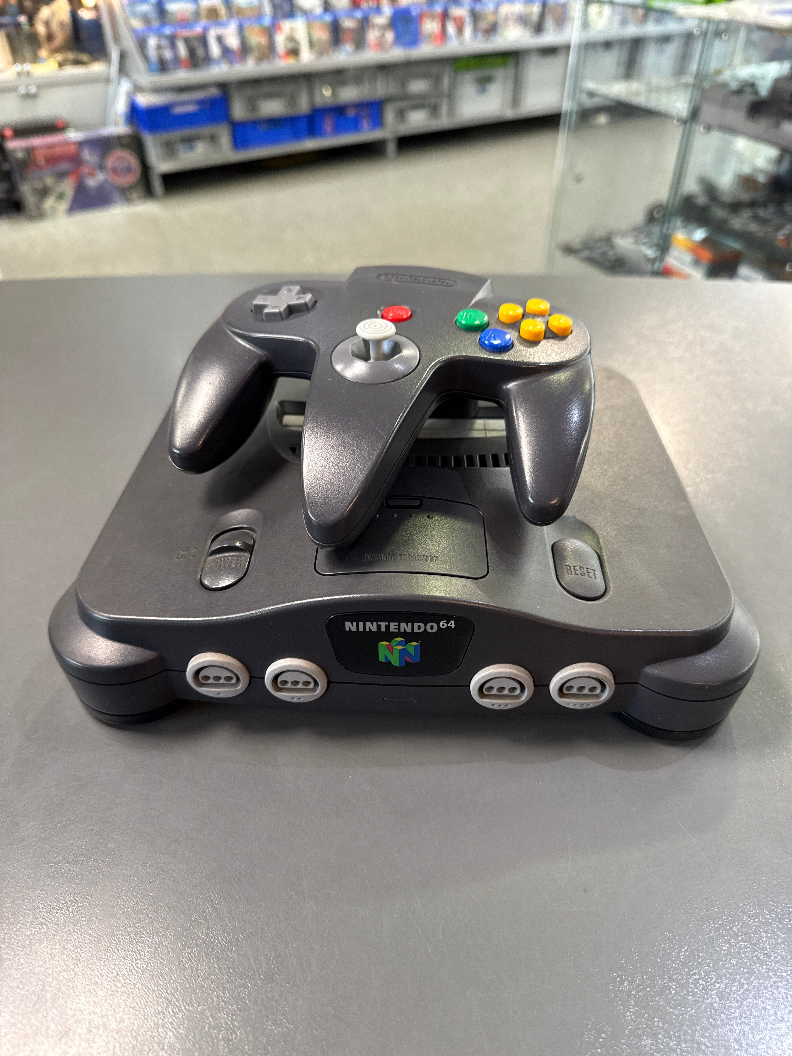 Original Nintendo 64 Konsole mit klassischem N64-Controller im grauen Retro-Design der 90er Jahre.