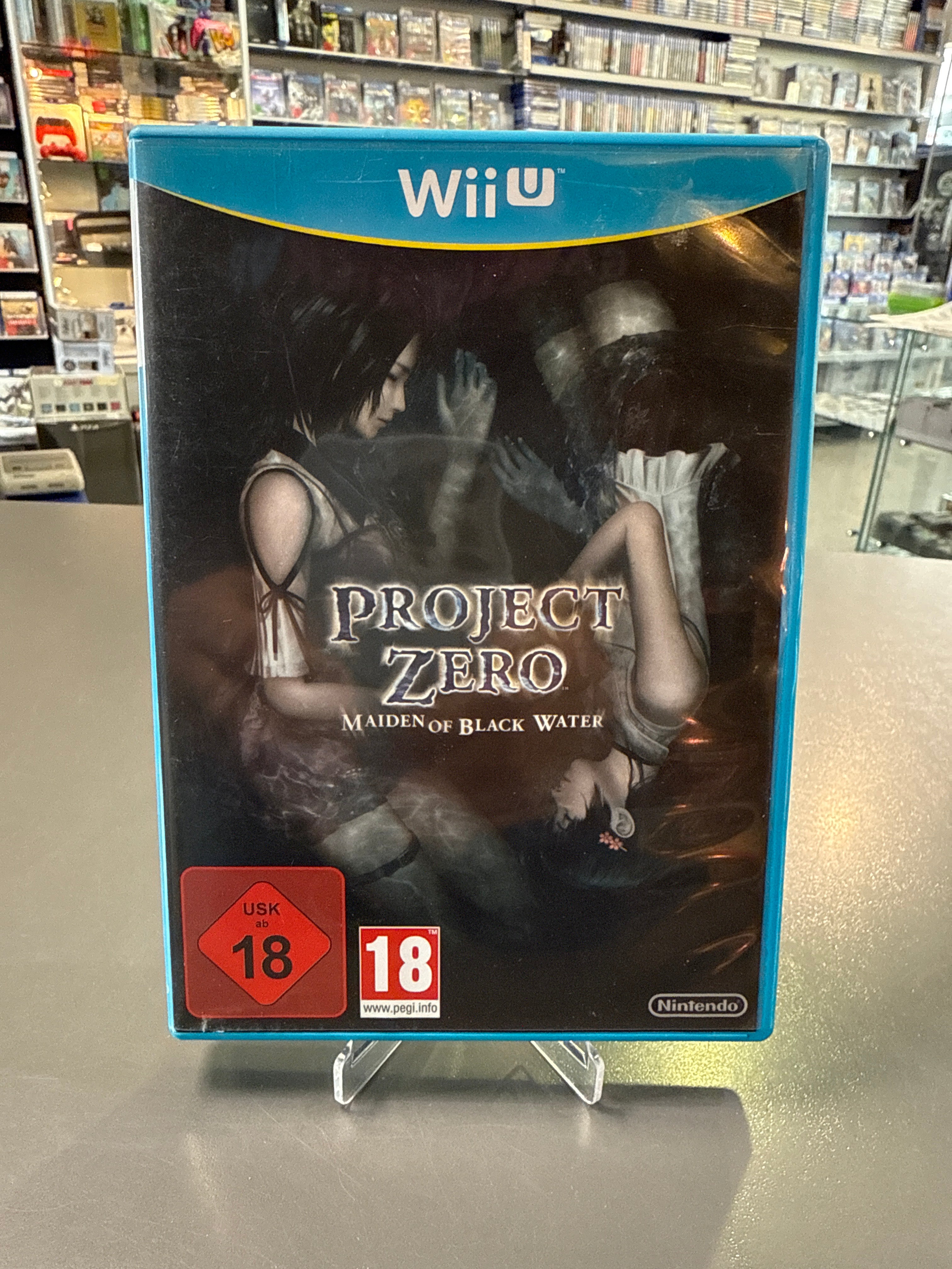 Cover von Project Zero: Maiden of Black Water für Wii U mit düsterem Horror-Design, nebliger Atmosphäre und übernatürlichen Charakteren.